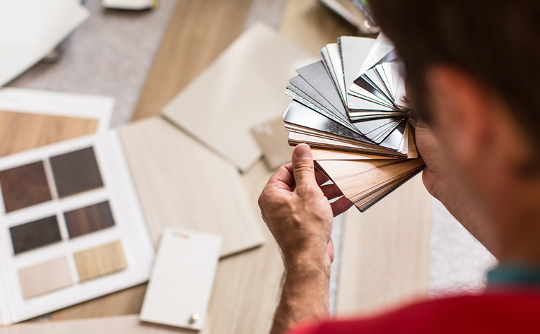 man looking at flooring samples and swatches